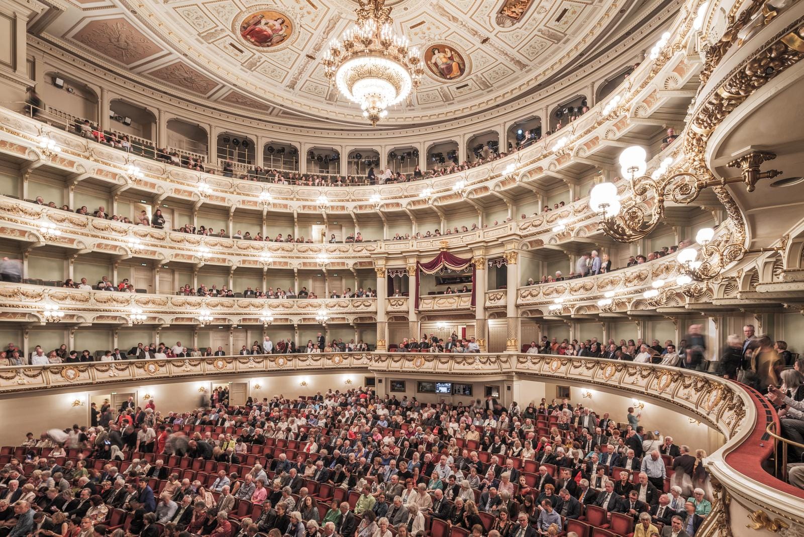 Prunkvolles Opernhaus mit üppigen Verzierungen und vollem Zuschauerraum.