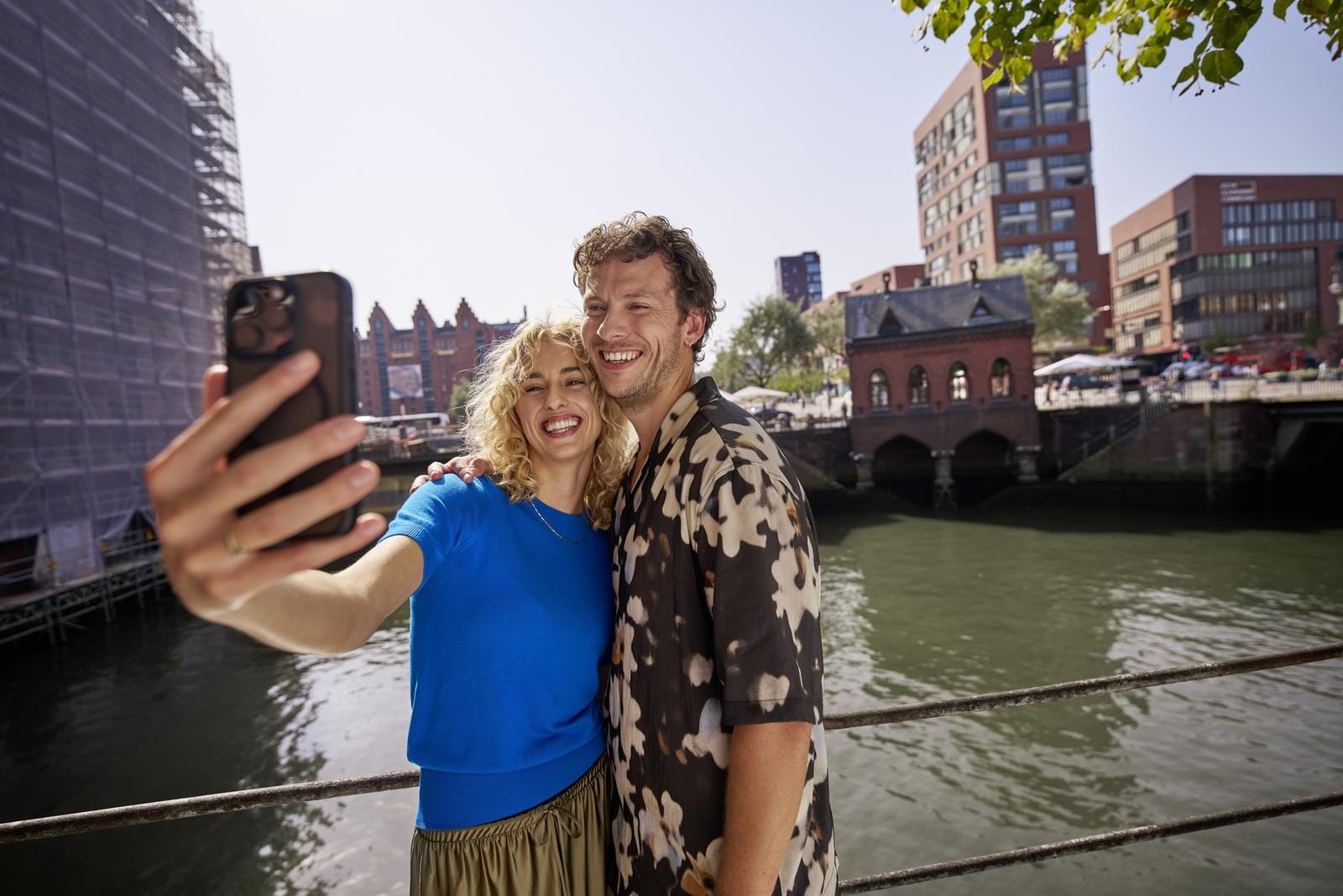 Pärchen macht Selfie vor Hamburger Speicherstadt bei sonnigem Wetter.