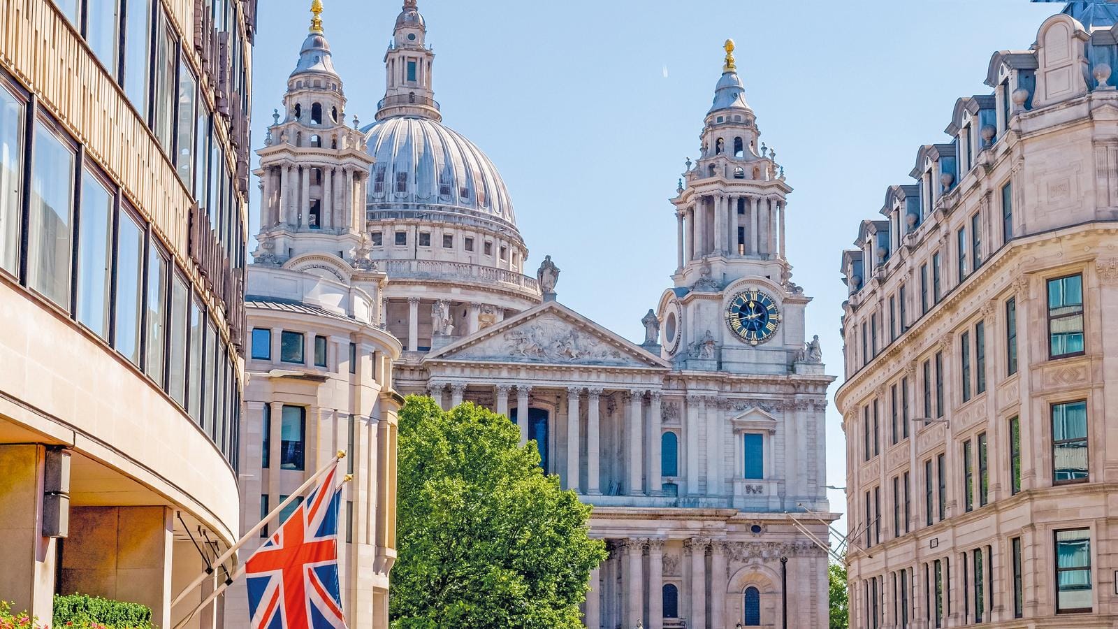 Majestätische Architektur in London, Großbritannien, mit der Union Jack vor strahlend blauem Himmel.