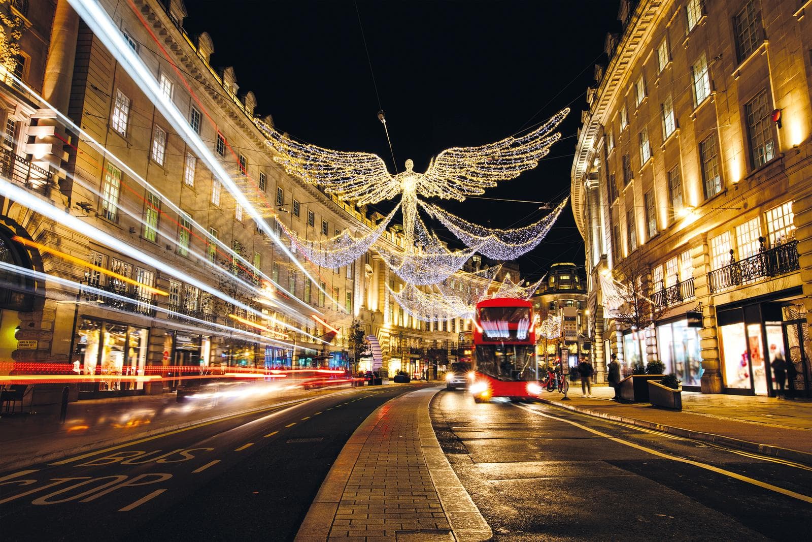 Regent Street, London, nachts mit festlicher Beleuchtung und rotem Bus.