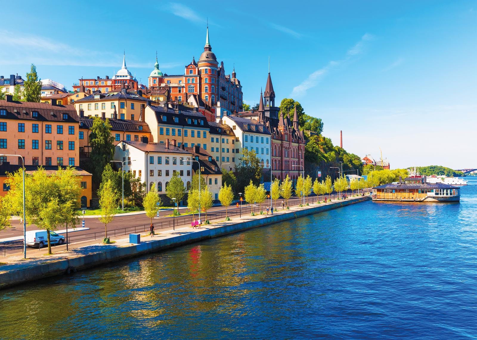 Bunte Fassaden an der Uferpromenade in Stockholm bei strahlend blauem Himmel.