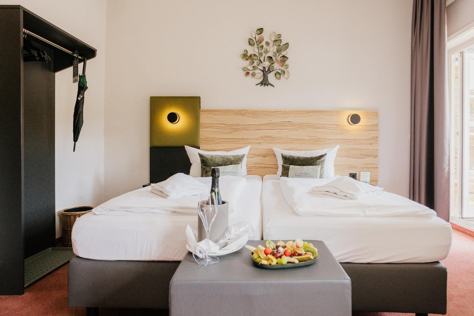 Helles Hotelzimmer mit Doppelbett, Holz-Elementen und moderner Dekoration, freundliches Ambiente.