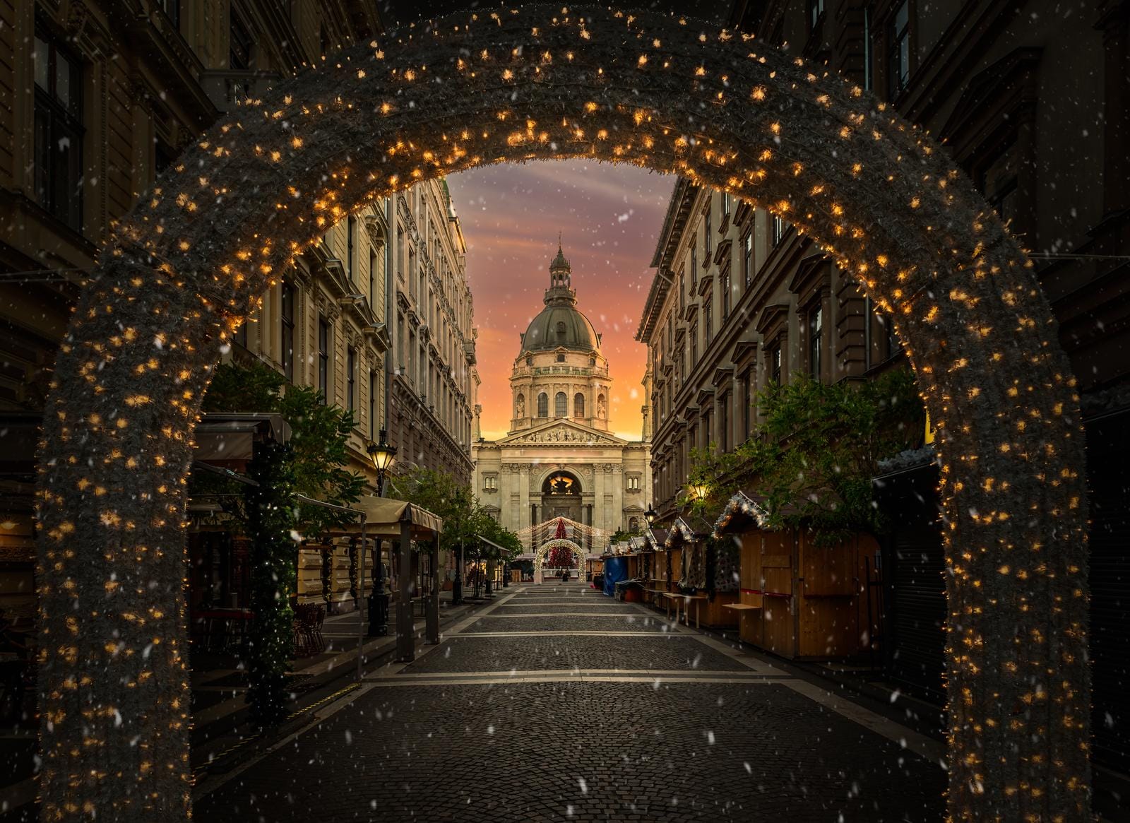 Beleuchtete Gasse in Budapest mit Ausblick auf die St.-Stephans-Basilika bei Sonnenuntergang.