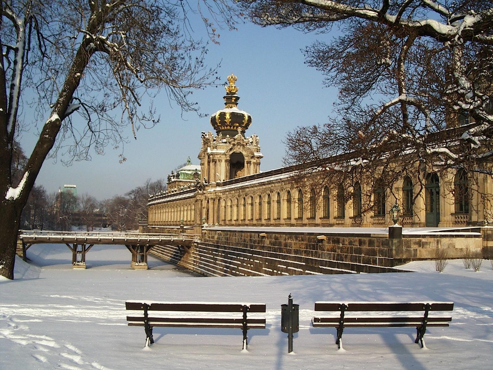 Verschneiter Hof in Dresden, Deutschland, mit historischem Gebäude und winterlicher Landschaft.