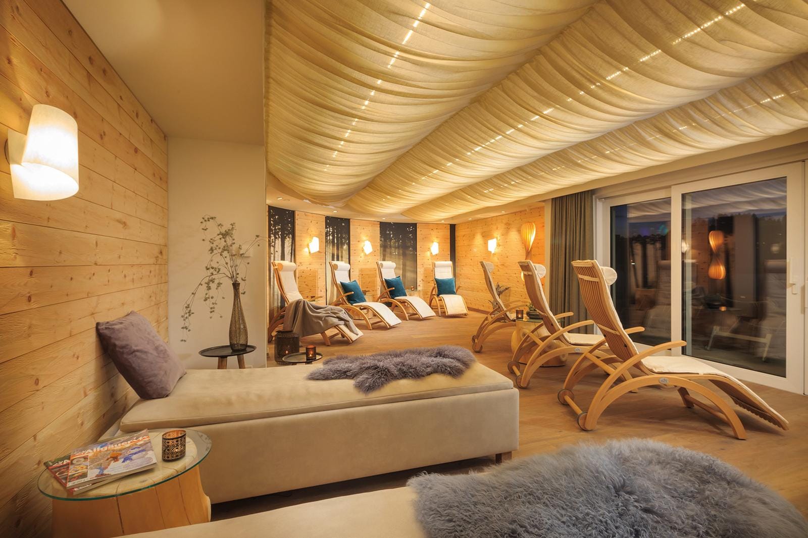 Gemütlicher Spa-Raum mit Holzwänden, Liegestühlen, und weicher Beleuchtung.