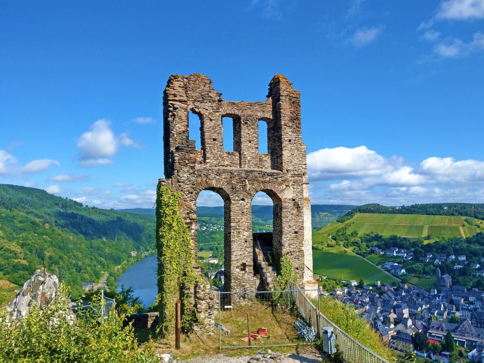 Ruine in Deutschland mit Blick auf grüne Hügel und Flusslandschaft bei klarem Himmel.