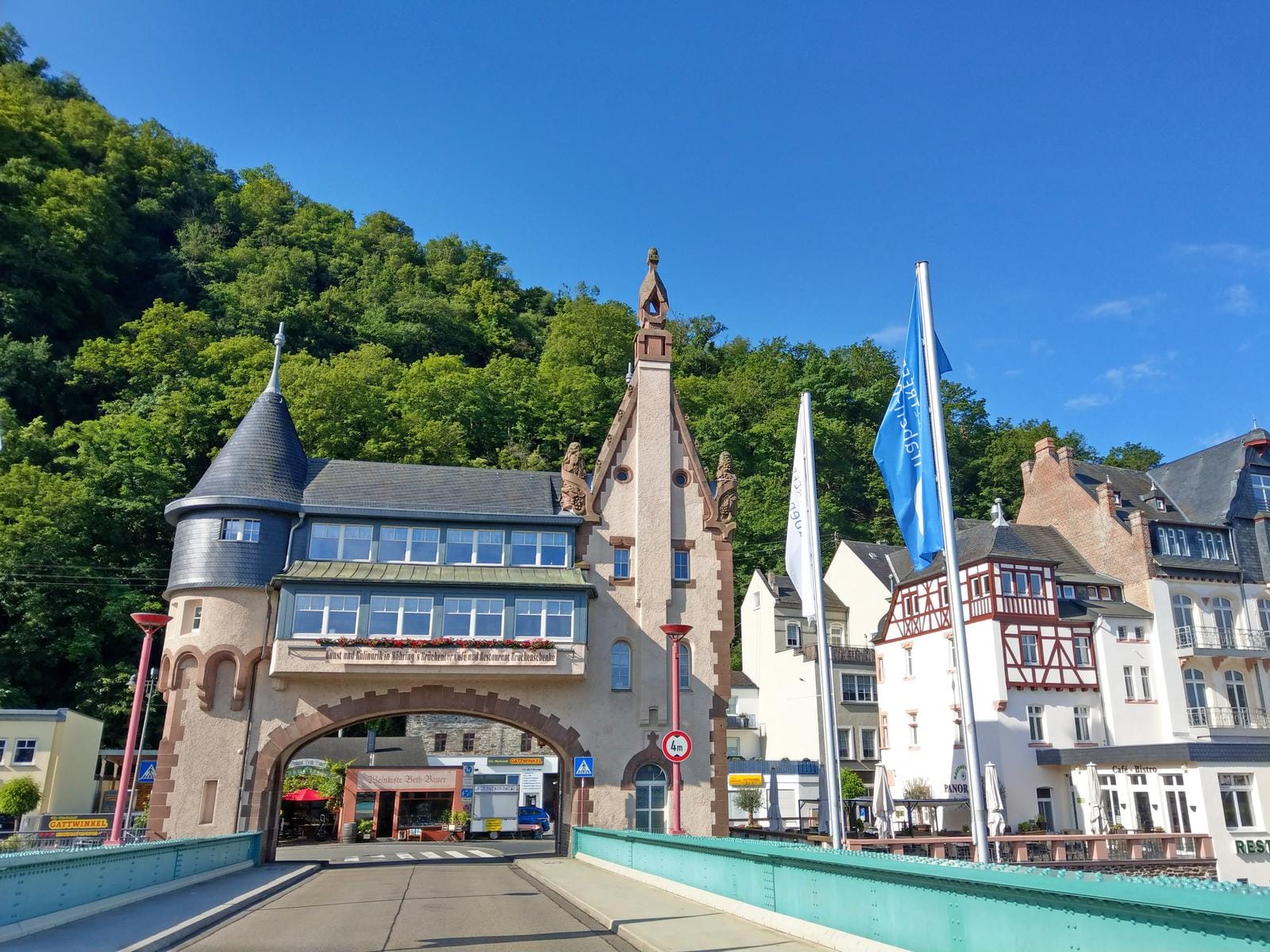 Historisches Stadttor und Fachwerkhäuser in Traben-Trarbach, Deutschland, bei blauem Himmel.
