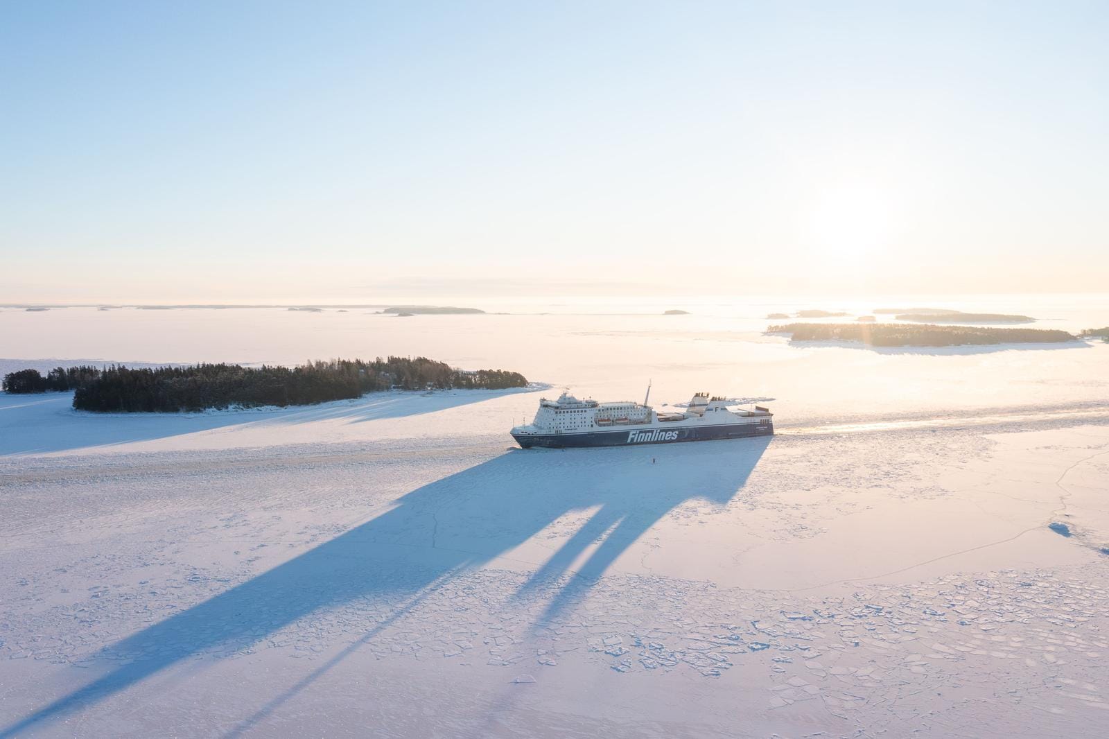 Eisbrechende Fähre in winterlicher Ostsee mit klarer Morgenstimmung und Inseln.