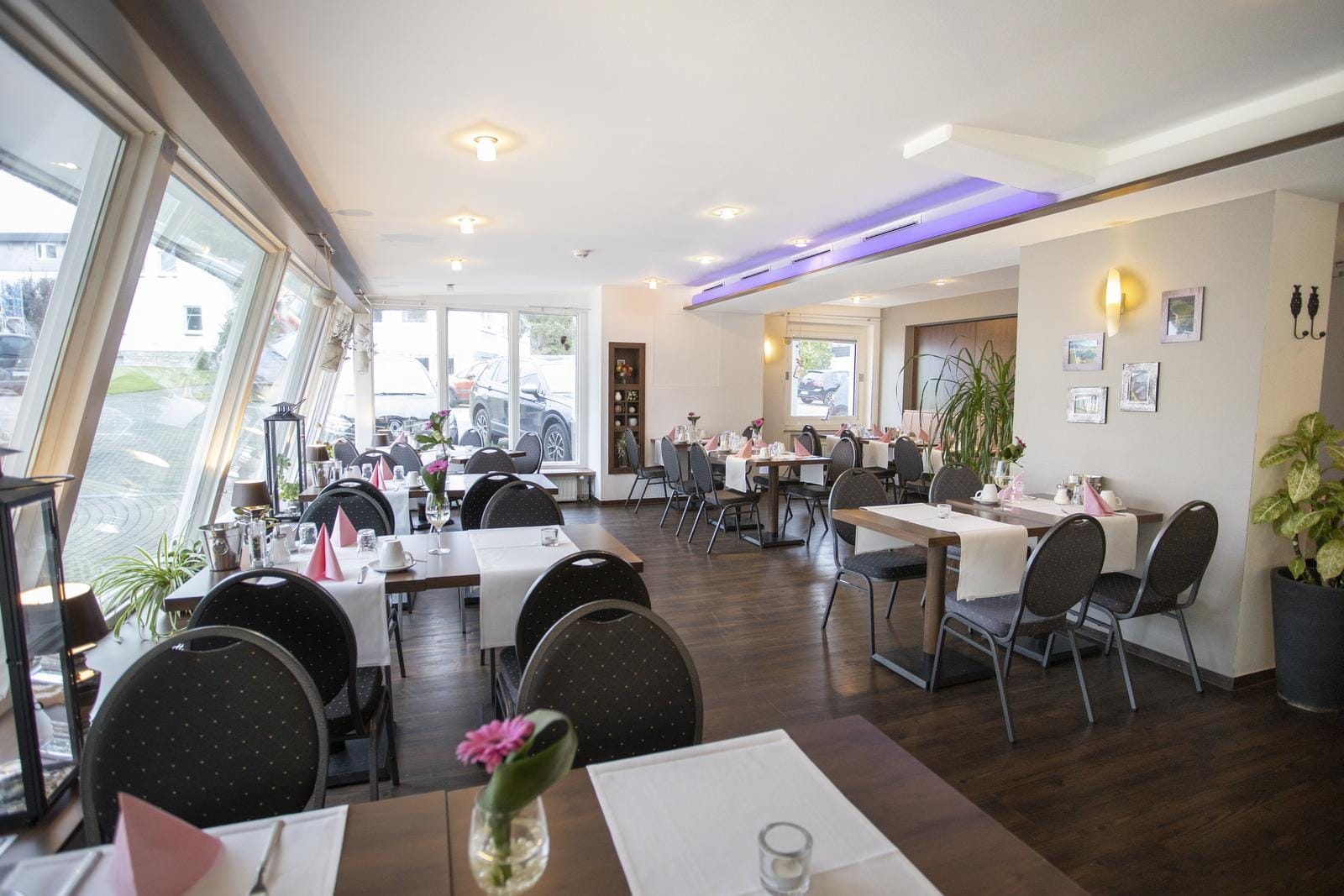 Helles, modern eingerichtetes Hotelrestaurant mit großen Fenstern und gemütlichem Ambiente.