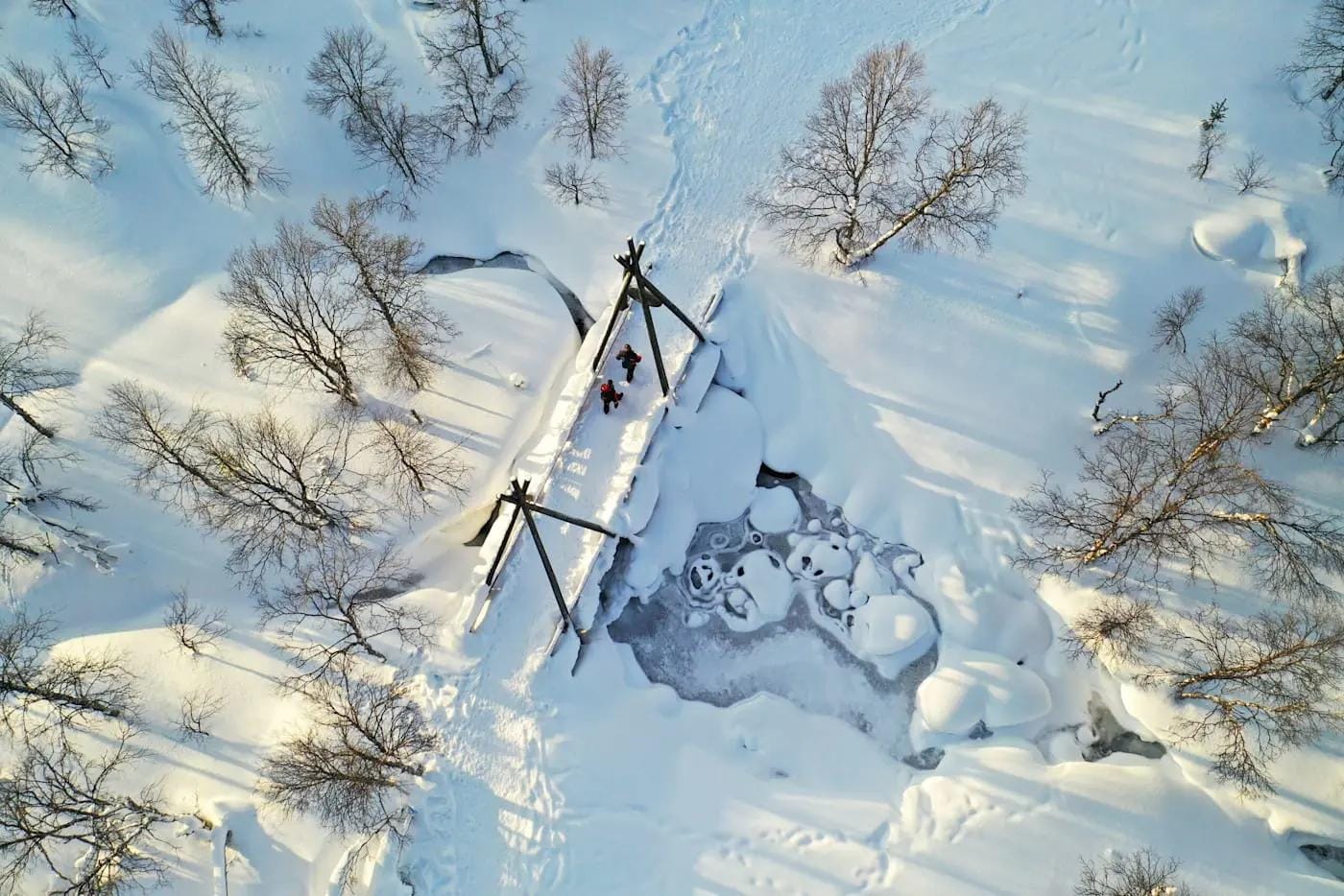 Winterliche Landschaft in Lappland, Finnland, mit verschneiten Bäumen und gefrorenem Fluss.