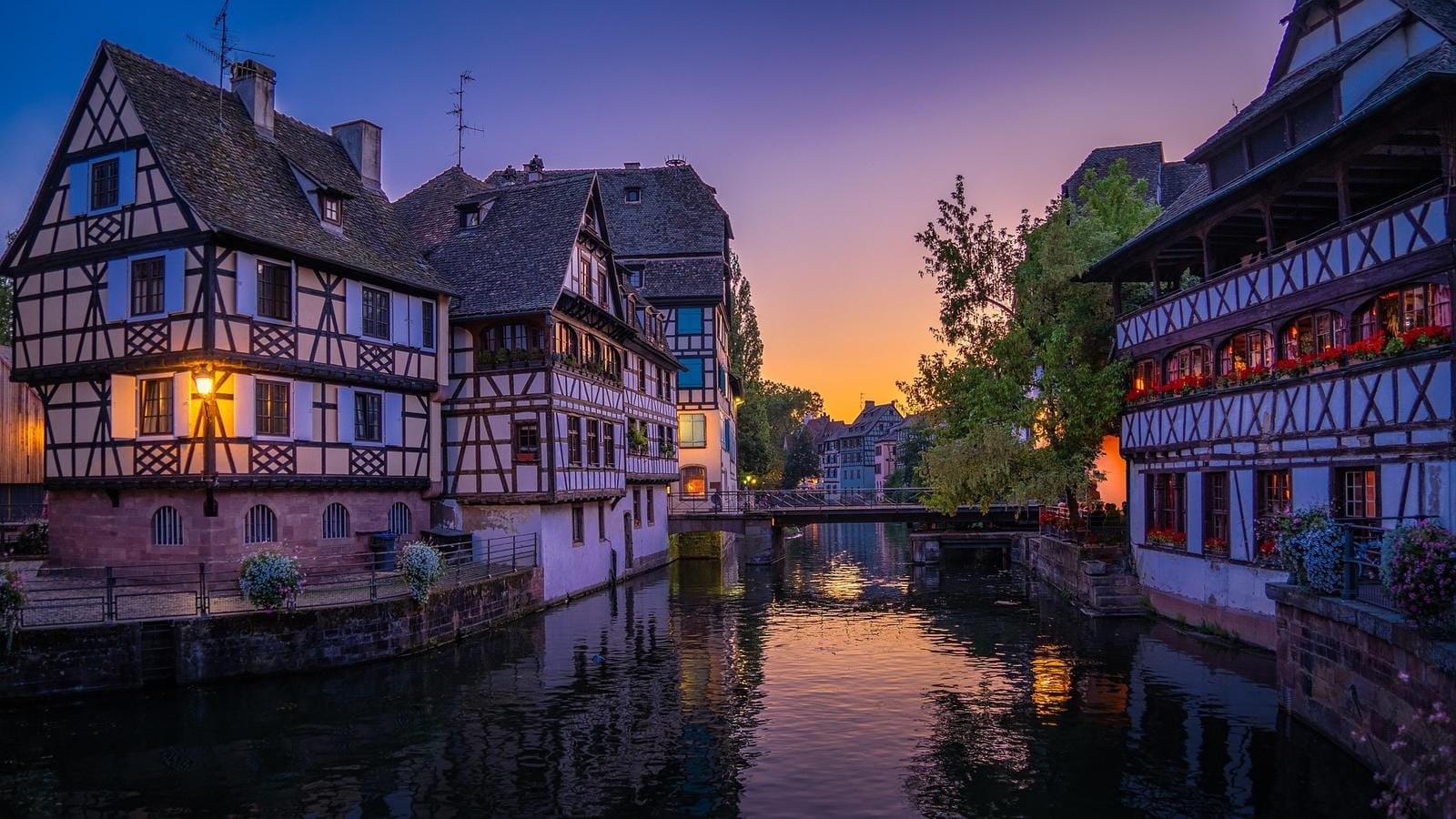 Fachwerkhäuser in Straßburg, Frankreich, bei Sonnenuntergang spiegeln sich im Kanal.