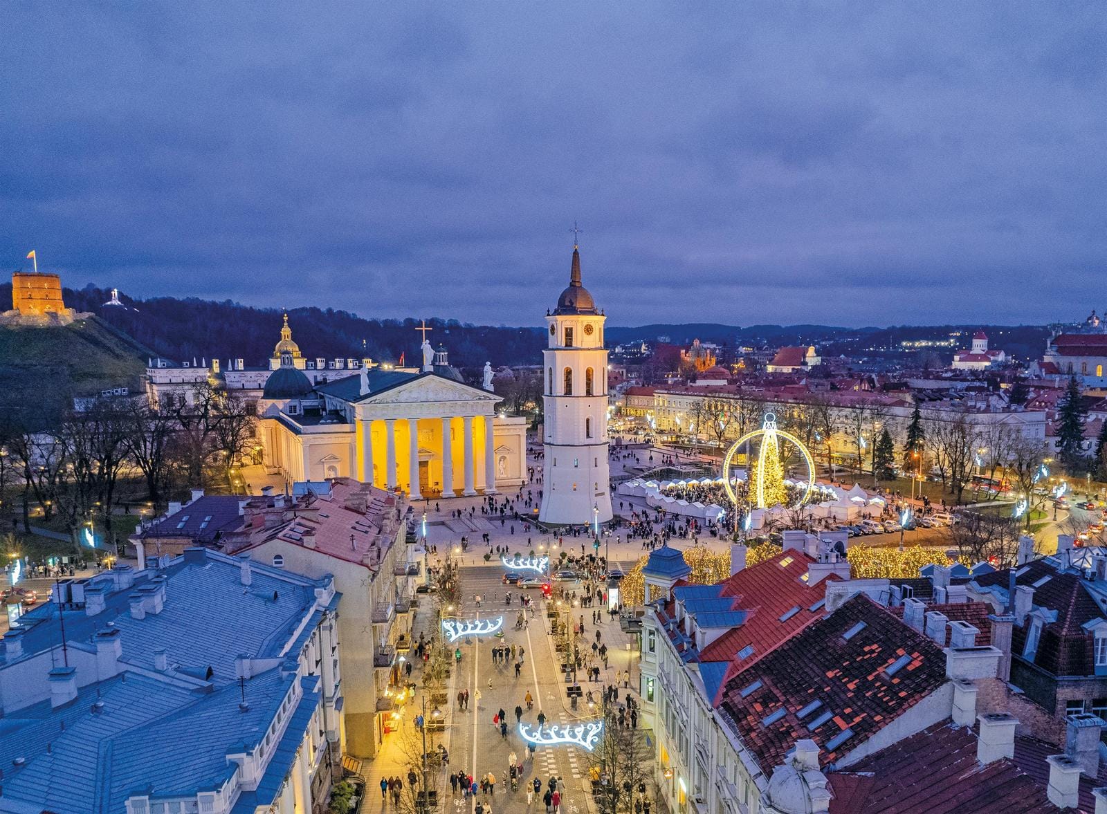 Blick auf Vilnius, Litauen, beleuchtete Altstadt mit Kathedrale und Glockenturm bei Nacht.